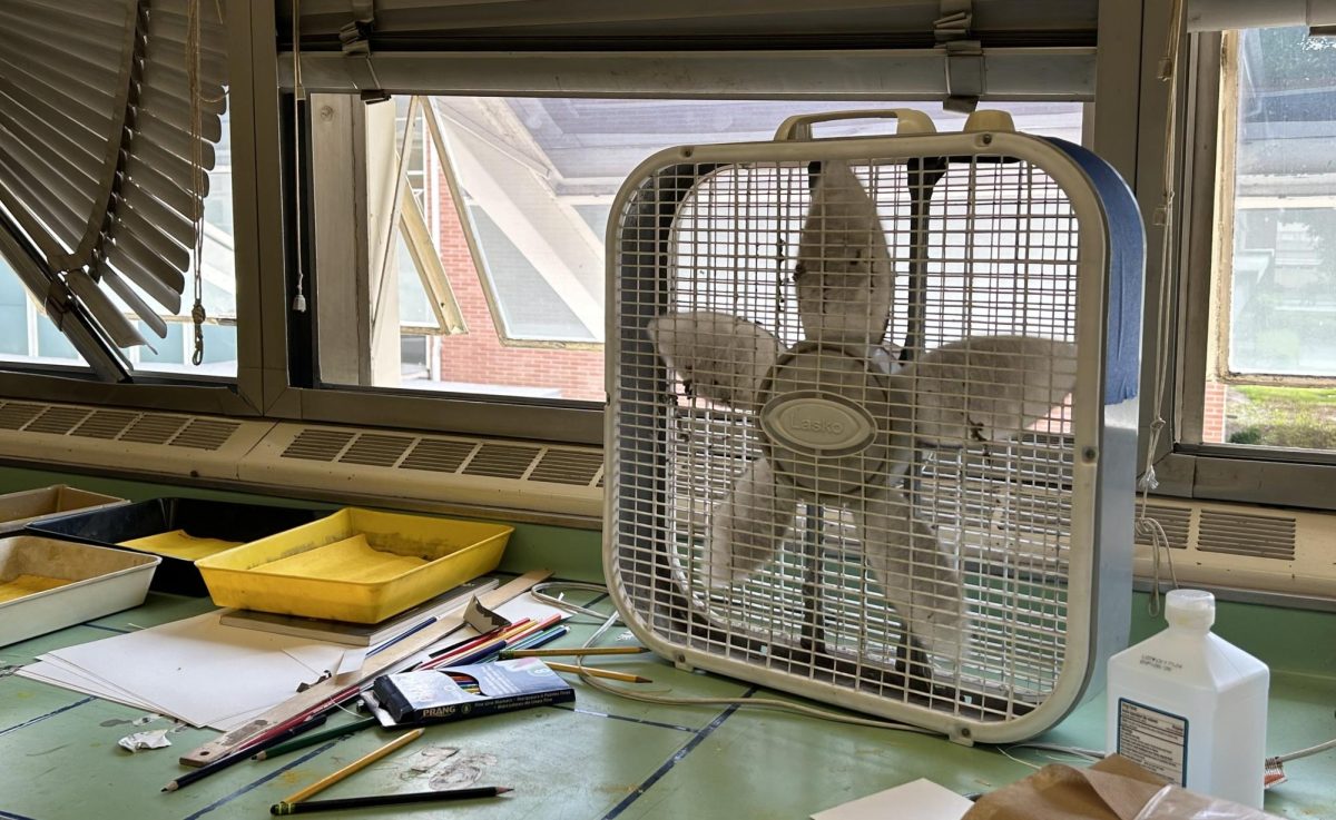 Photo of a classroom box fan in front of open windows.