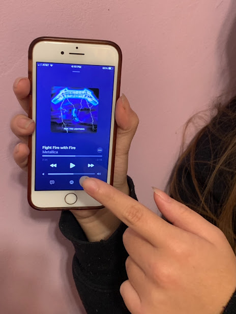 Photo of a student listening to one of Metallicas albums. 
