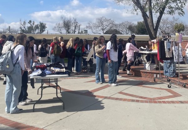 Photo of students shopping at the pop-up thrift shop in the quad. 