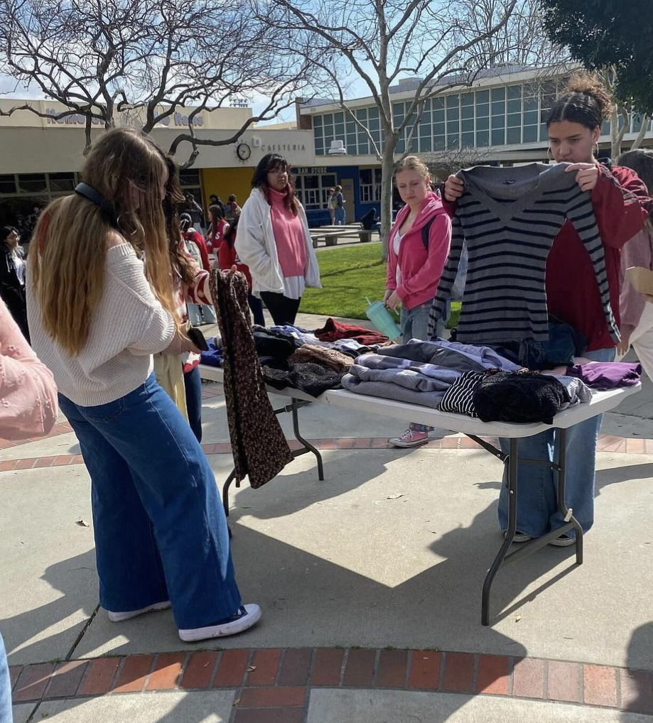 Photo of students shopping at the pop-up thrift shop in the quad. 