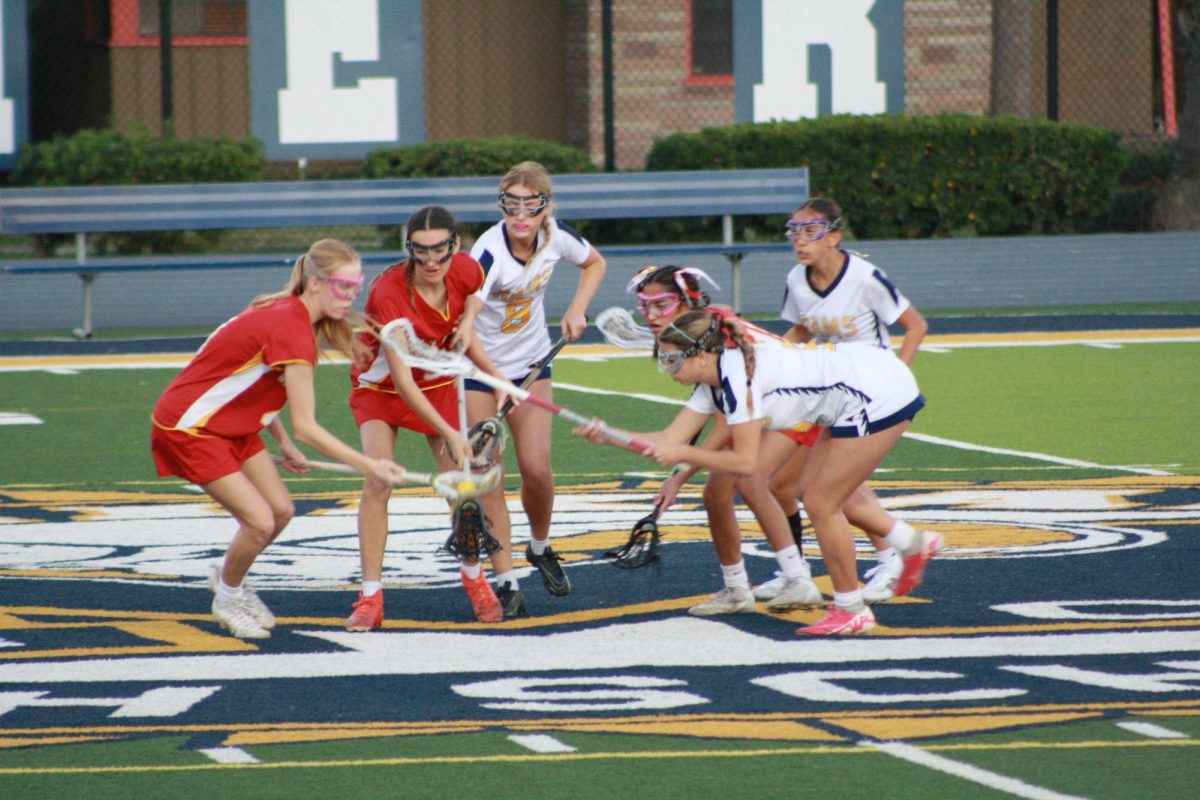 Photo of Millikan's Girls Lacrosse in a face-off at mid-field. (Photo by: Emma Croff) 