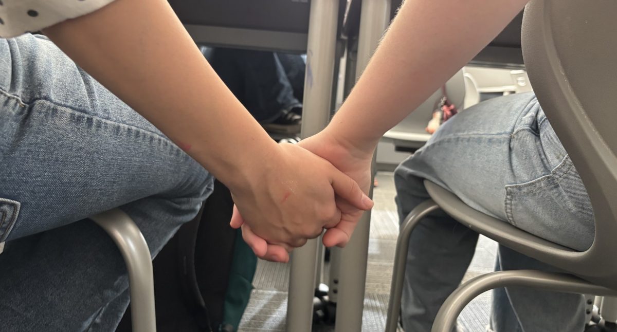 Photo of two students holding hands 
