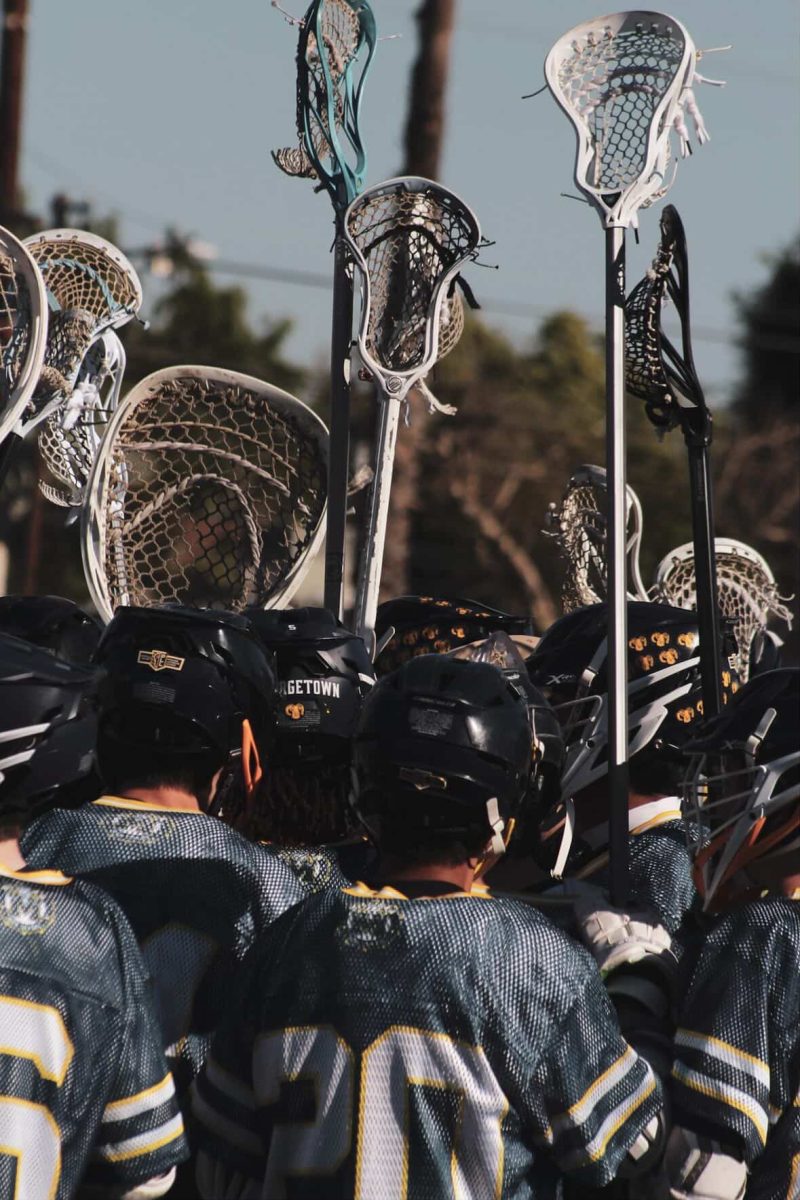 Photo of lacrosse player's sticks in the air.